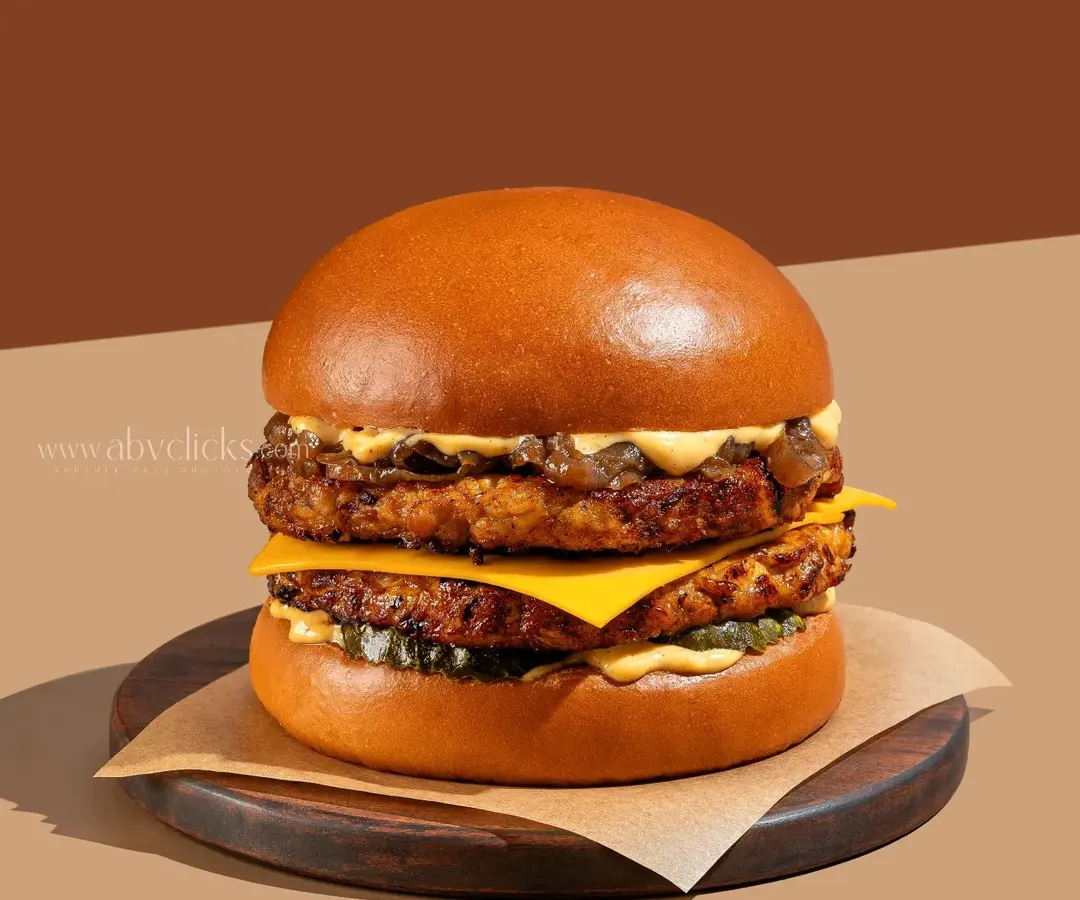 A perfectly stacked double-decker burger with melted cheese and fresh toppings, captured with clean, bright lighting to emphasize its juicy, appetizing details.