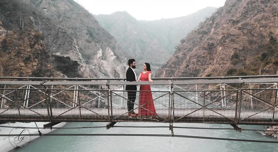 For adventurous couples, a destination pre-wedding shoot is a must. Here, we used the stunning landscape of Rishikesh, with the bridge over the river creating a dramatic and unforgettable backdrop for their love story.