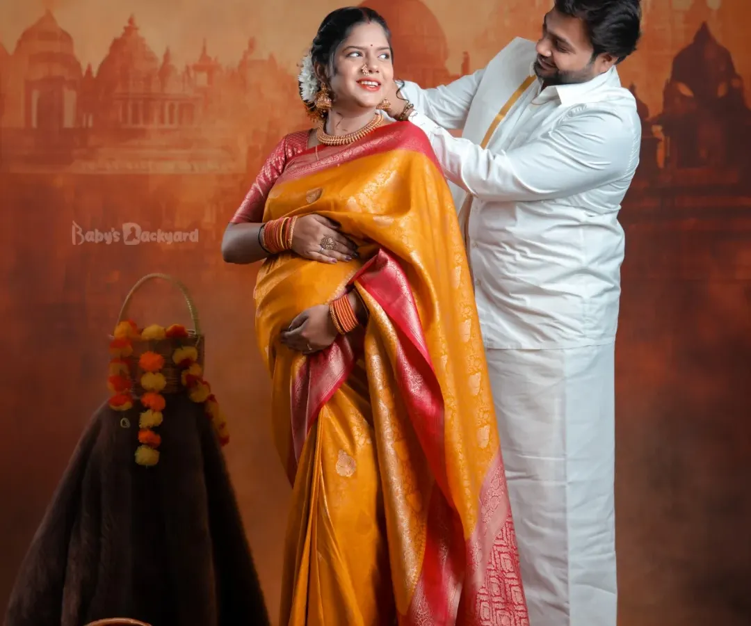 We celebrate your journey into parenthood by weaving in the beauty of your traditions. This couple's portrait, set against a classic backdrop, captures the warmth and richness of a South Indian maternity celebration.
