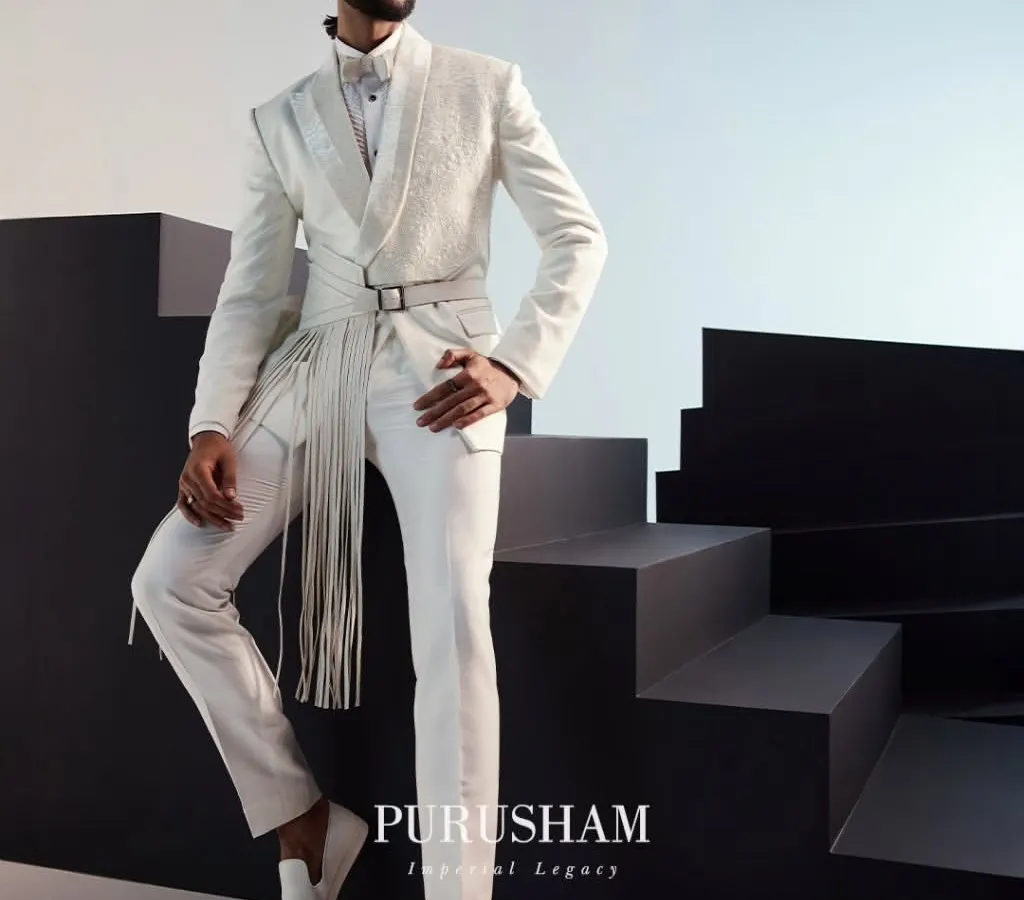 I believe white is a power statement. This ensemble redefines the classic white suit with a modern, architectural silhouette, featuring a structured jacket with a dramatic, fringed belt. It is a look for the man who appreciates classic tailoring but demands a contemporary edge.