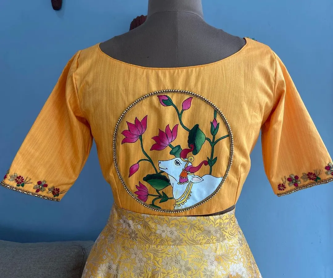 A custom-designed yellow blouse featuring a hand-painted Pichwai art motif on the back. This piece combines traditional Indian art with modern tailoring, a specialty I offer for clients seeking truly unique ethnic wear.