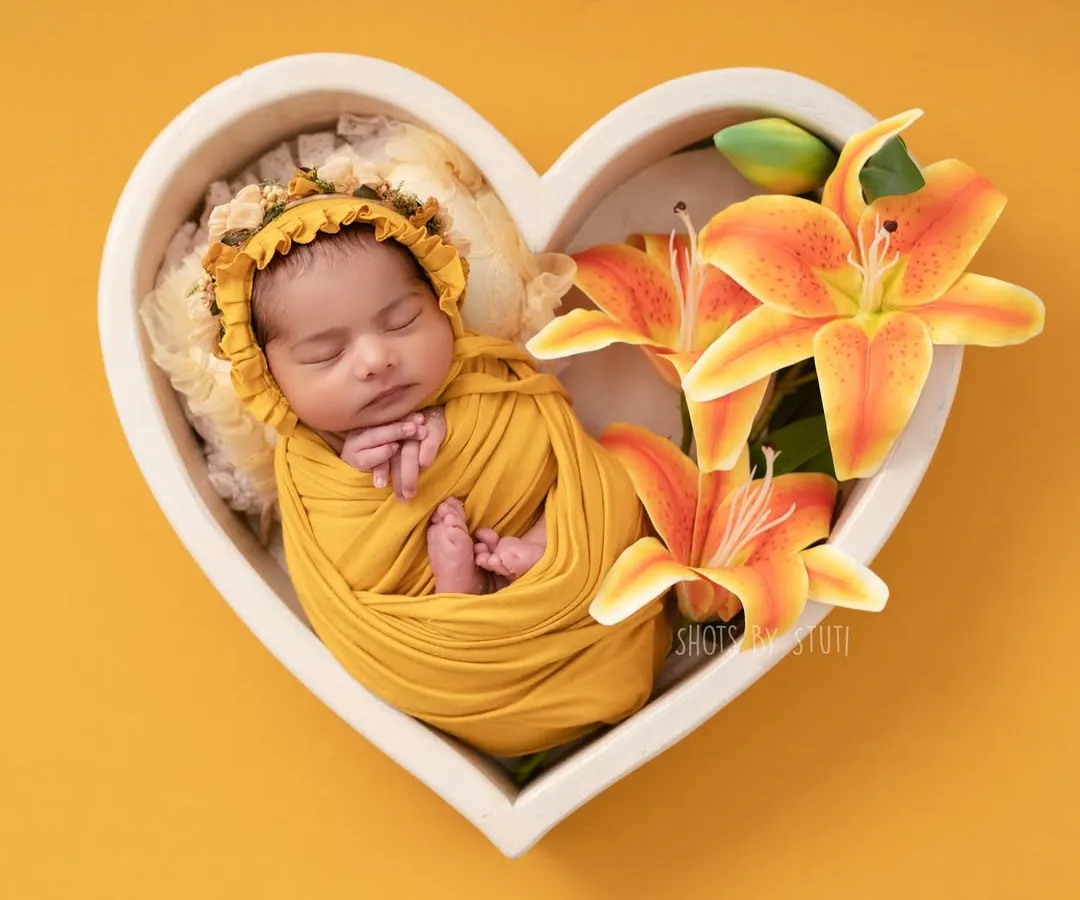 This is what I mean when I say I preserve memories. A perfectly peaceful newborn, nestled in a heart bowl, surrounded by warmth and love. Every detail, from the soft wrap to the delicate flowers, is chosen to create a timeless portrait of these fleeting first days.
