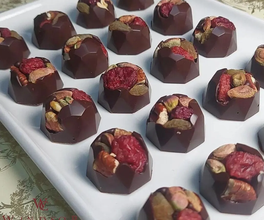 A closer look at the craft. These are my dark chocolate bonbons filled with a mix of toasted pistachios, almonds, and dried raspberries. I use only premium couverture chocolate and natural ingredients, ensuring every bite is a perfect balance of flavor and texture.