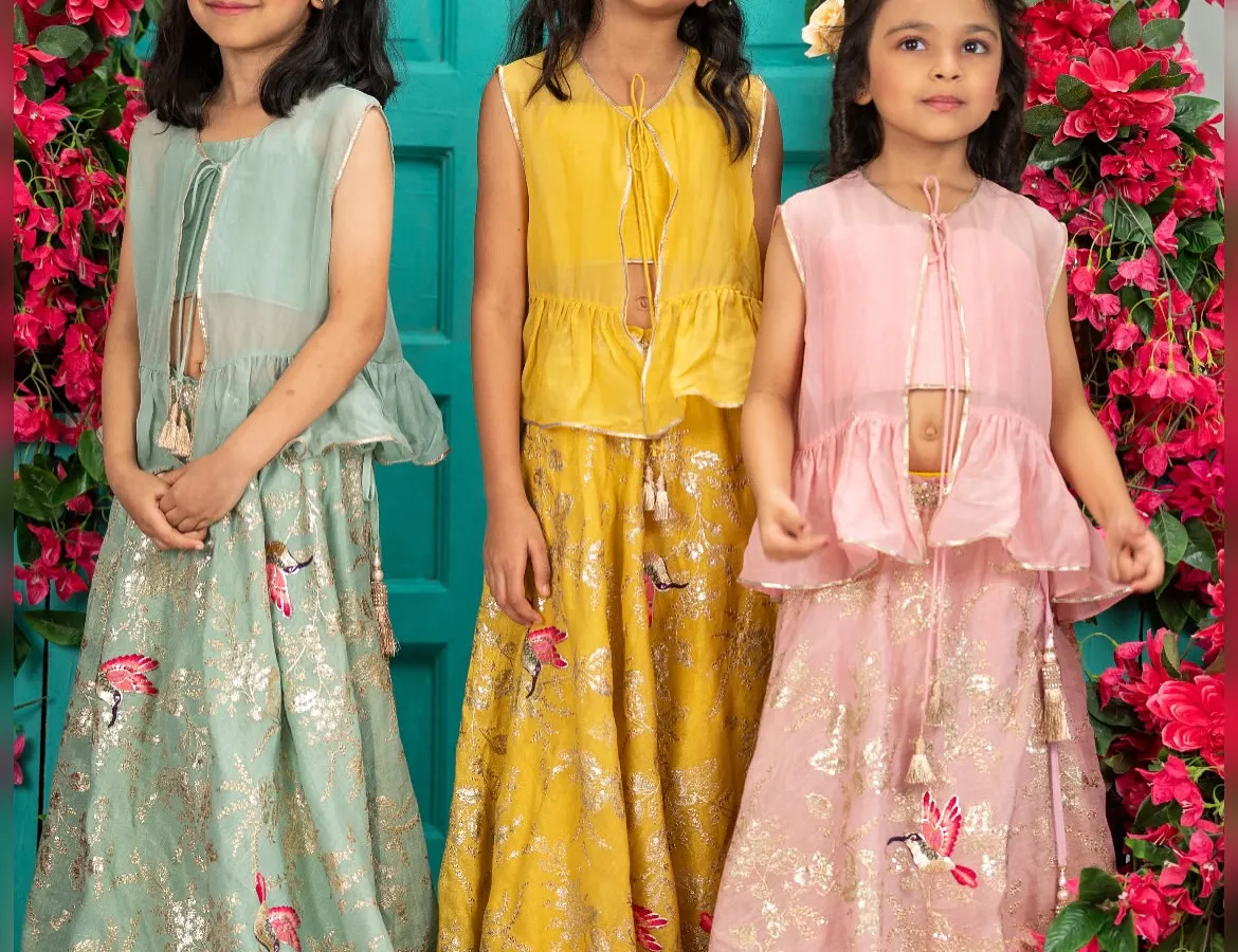 For the sweetest sister squads, I design dreamy lehenga sets in soft pastel shades. This image shows my popular peplum top and skirt sets in pastel green, mustard yellow, and blush pink, all crafted from breathable Pure Chanderi fabric so they can play and pose in complete comfort.
