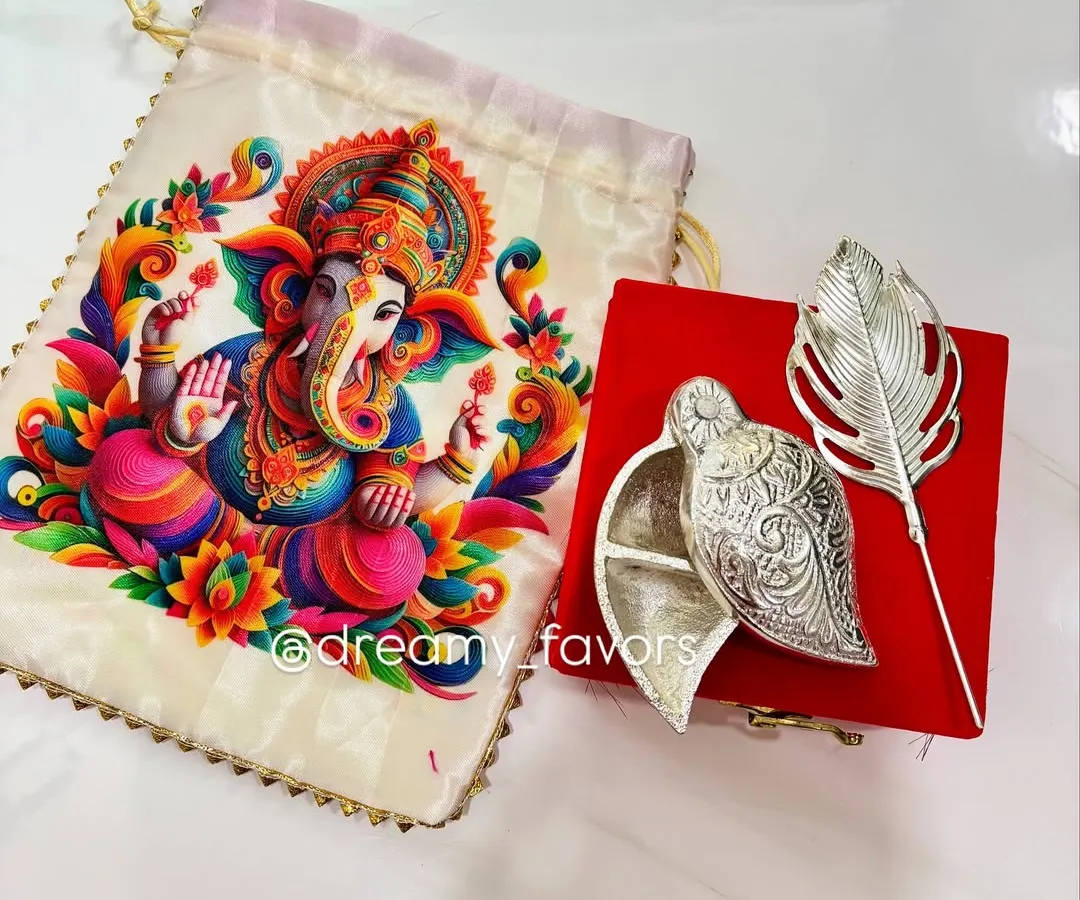 This is one of my favorite return gifts for Ganesh Chaturthi. It features an elegant silver-coated Tilak Dibbi box paired with a vibrant Ganpati print potli bag. It's a beautiful blend of tradition and artistry that your guests will cherish.