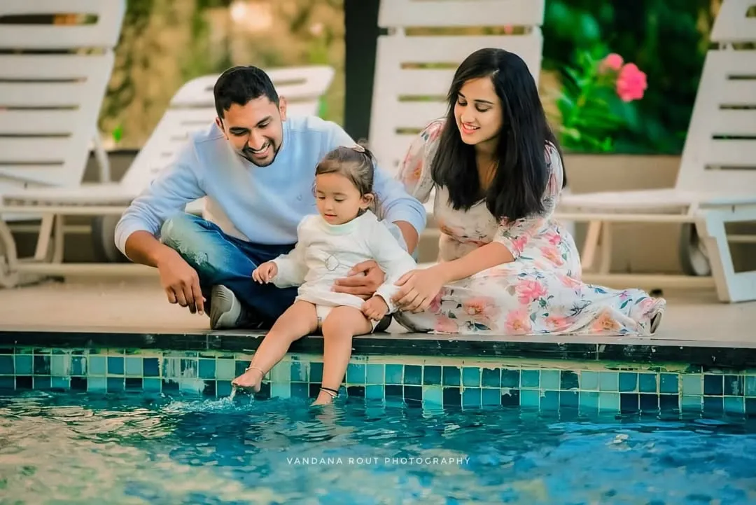 I believe the best family portraits happen when you're just enjoying each other's company. This relaxed, outdoor family photoshoot by the water captures a genuine moment of connection and playfulness between parents and their little one.