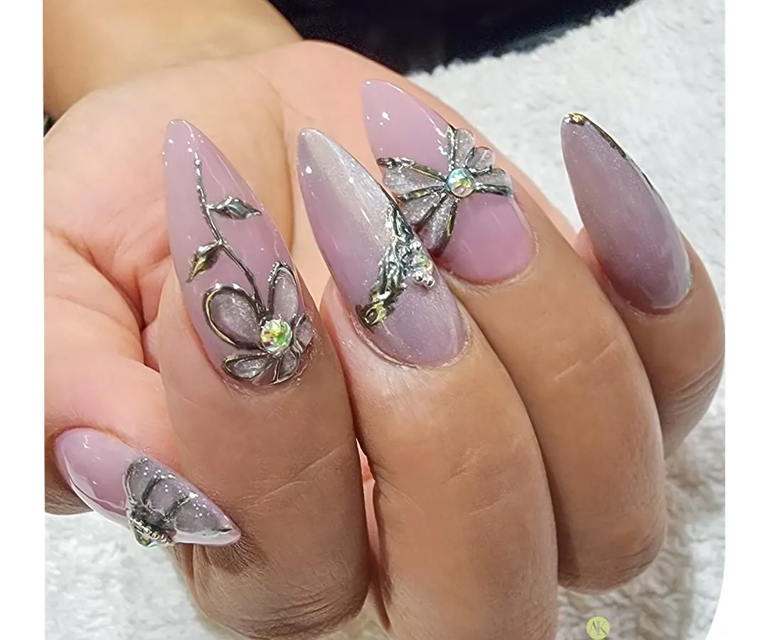 For a touch of luxury, I added these sculpted 3D floral and bow embellishments. Set against a soft pink base on long stiletto nails, these silver accents and rhinestones add dimension and high-end glamour.