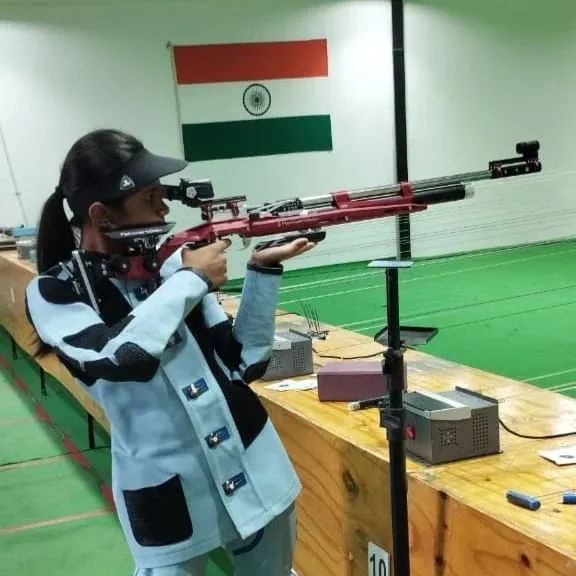 A student in full competition gear takes aim with a professional air rifle. We emphasize correct form, stance, and the use of proper shooting kits for peak performance.