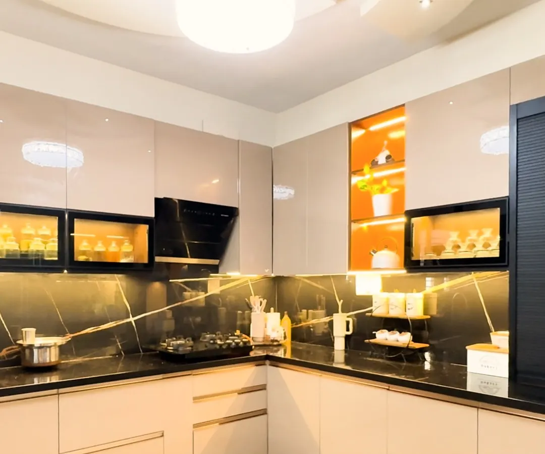 We believe a kitchen should be as beautiful as it is functional. This modular kitchen design features high-gloss laminate cabinets, a striking black marble backsplash, and integrated lighting to create a workspace that is both efficient and inspiring.