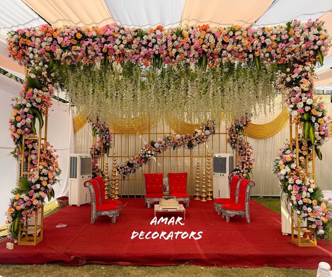 For this outdoor wedding, I designed a breathtaking floral mandap that felt both grand and natural. The canopy is lush with pastel roses and hanging white wisterias, creating the perfect sacred space for pheras under the open sky.