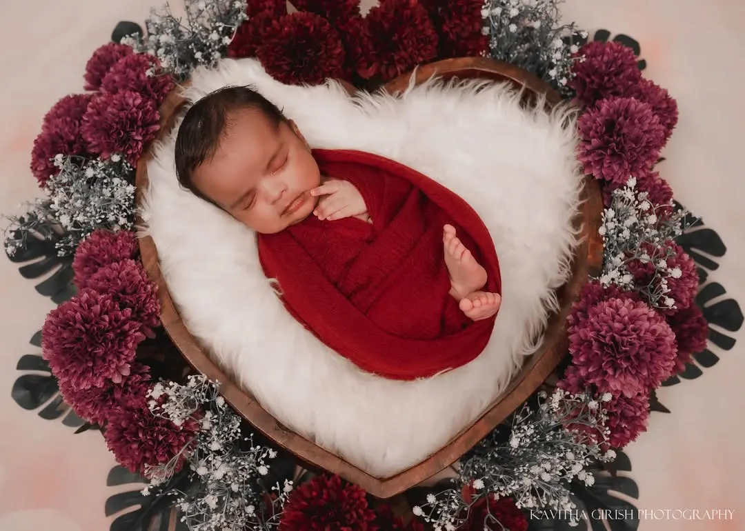 I believe every newborn is a tiny miracle. For this newborn portrait, we used a heart-shaped basket and rich, deep red tones to create a warm, love-filled setting that feels as precious as the baby sleeping inside.