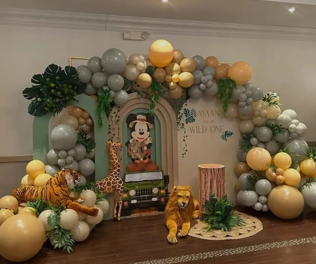 I bring magical worlds to life, like this "Wild One" safari adventure featuring Mickey Mouse. This large-scale backdrop combines custom cutouts, lush balloon garlands, and themed props to create an immersive experience for a child's special day.