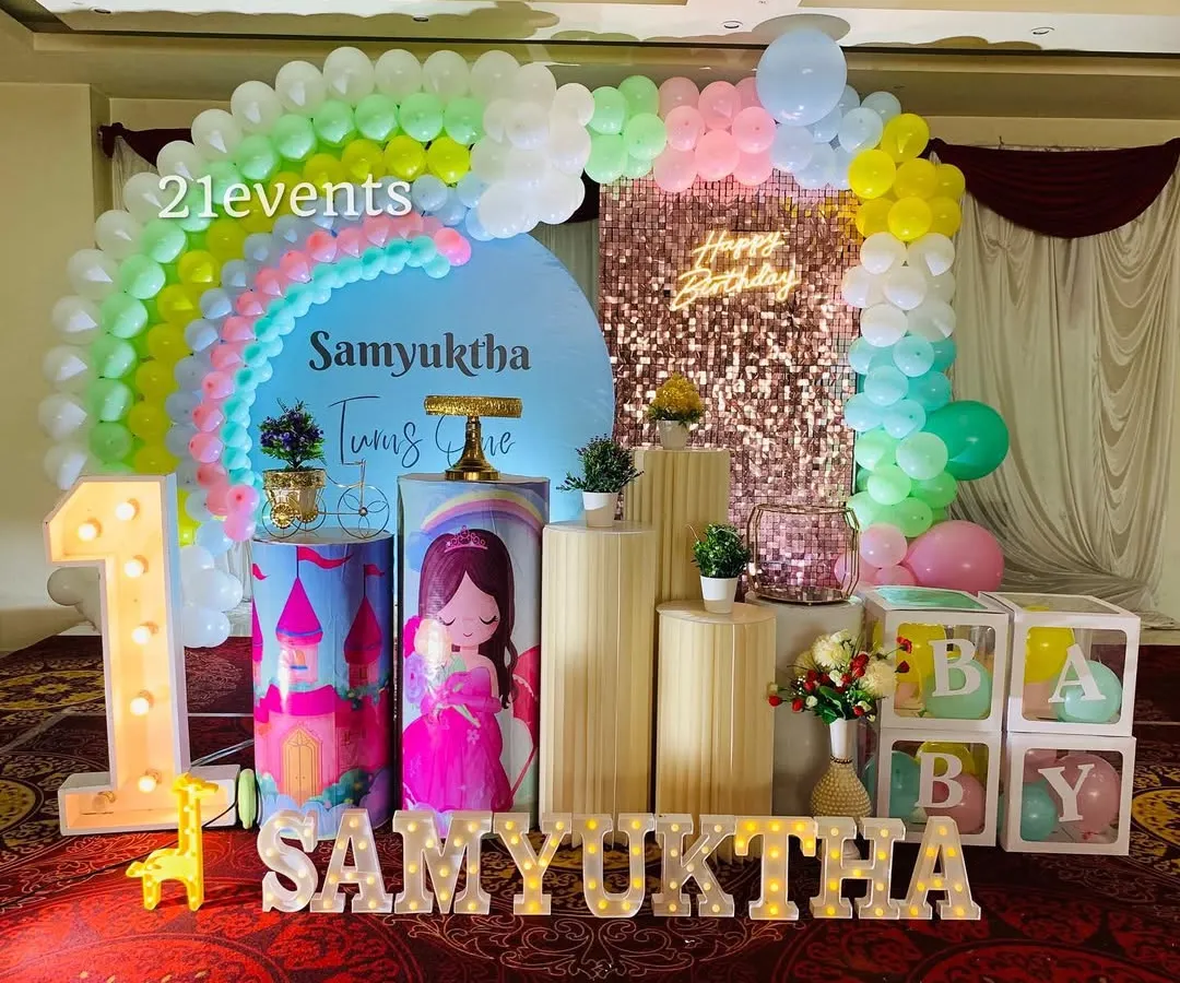 I love bringing colorful ideas to life, like this rainbow and princess combination for a first birthday. It features a pastel rainbow balloon arch, a sequin backdrop, a light-up marquee number, and custom-themed pedestals for the cake and desserts.