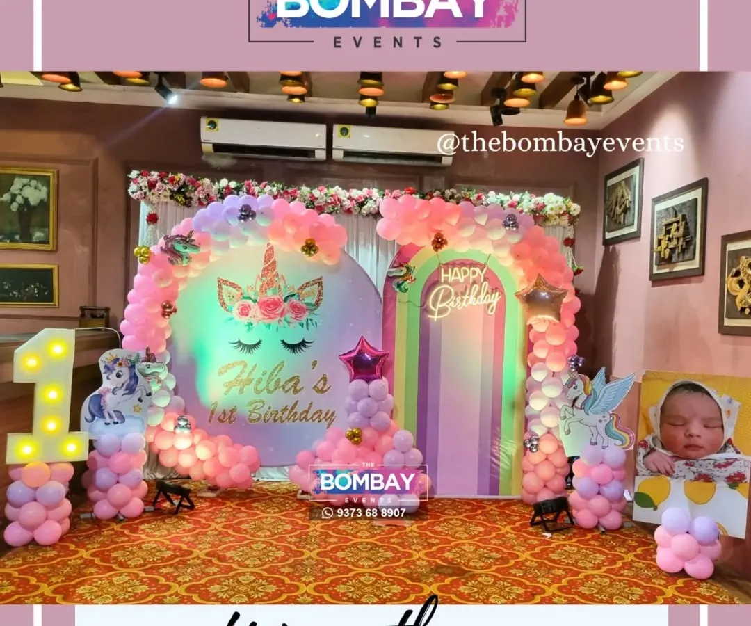 For a truly magical first birthday, I designed this dreamy unicorn theme. The setup includes a custom backdrop with the birthday girl's name, pastel pink balloon arrangements, and a light-up number '1' surrounded by unicorn cutouts.