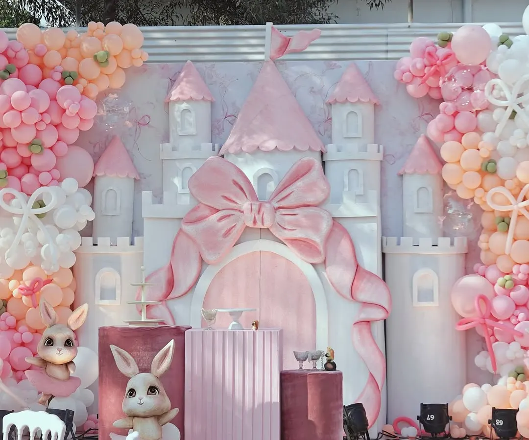 For a truly enchanting celebration, we designed this fairytale bunny and castle theme. The centerpiece is a custom-built castle with a large pink bow, surrounded by plush bunnies, elegant pedestals, and a soft pastel balloon arrangement, creating a magical photo opportunity for a first birthday or baby shower.