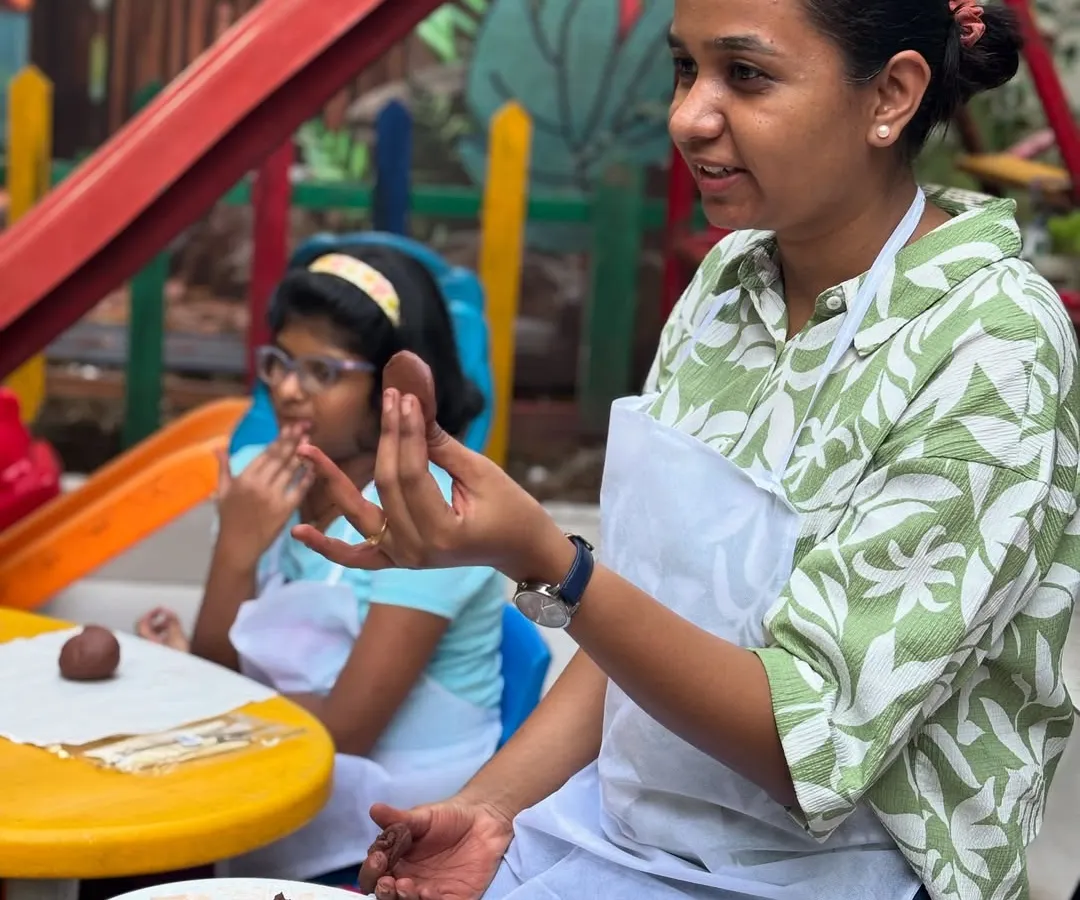 As an art therapist, I provide gentle, hands-on guidance. Here, I'm demonstrating a clay modeling technique during an outdoor workshop, ensuring each child feels supported in bringing their vision to life.