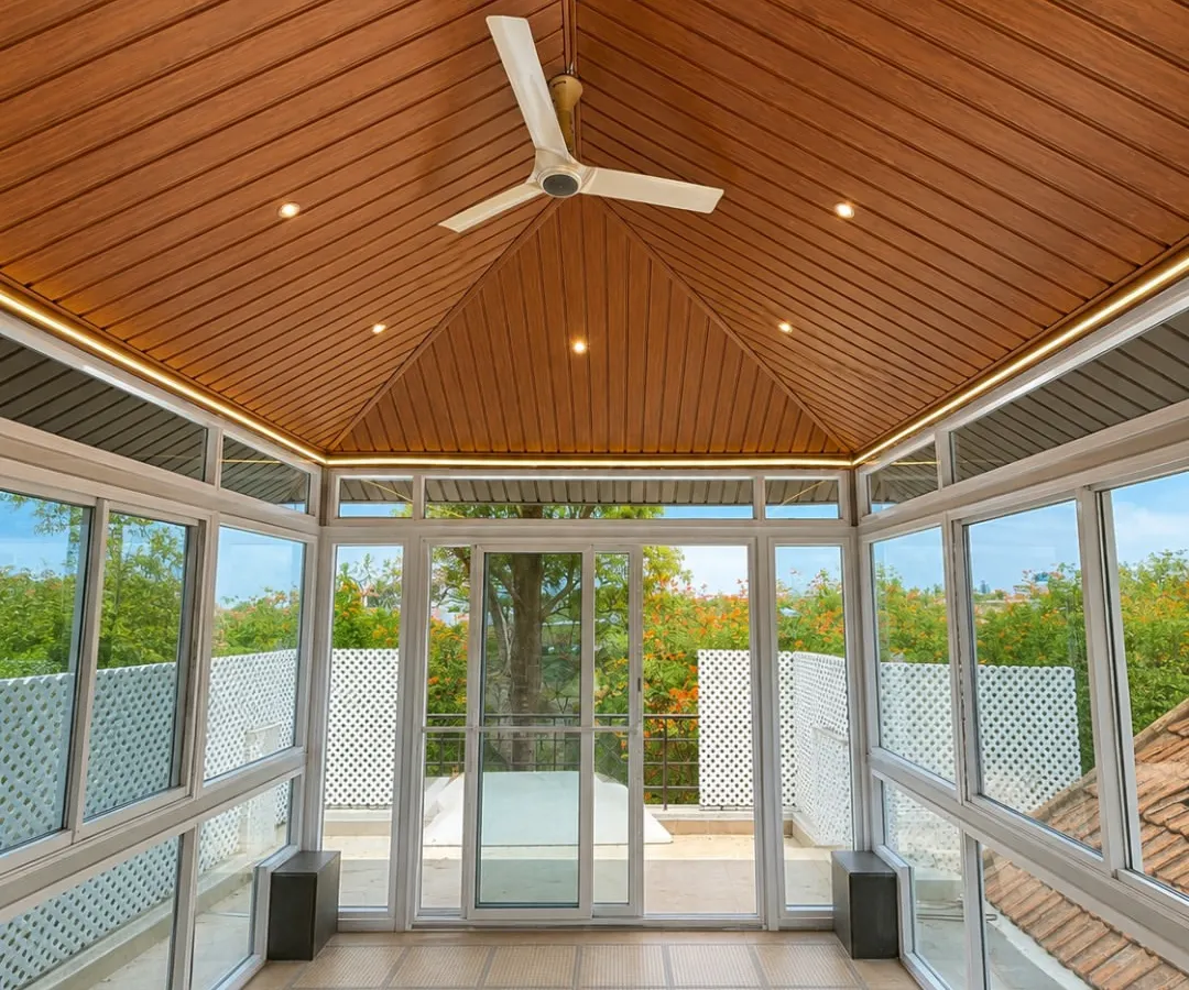 Step inside your personal, all-weather retreat. This view from within a completed glass room shows how we seamlessly blend the comfort of the indoors with the beauty of the outdoors, featuring a premium wood-finish ceiling, integrated fan, and panoramic views.