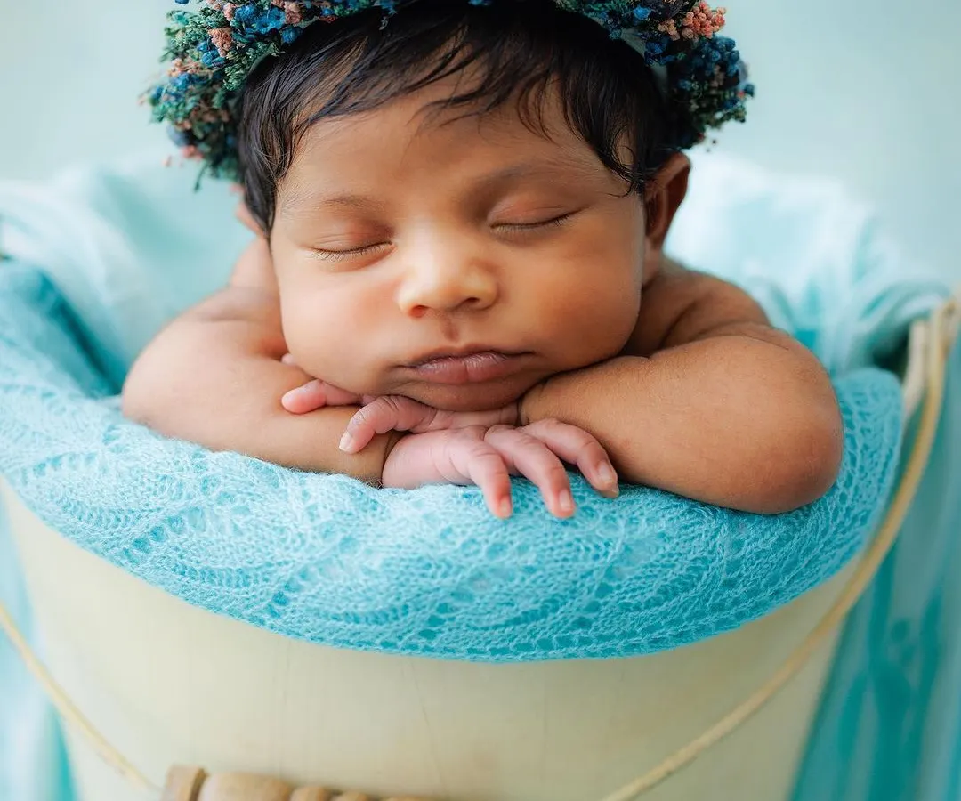 This is the heart of my newborn photography. A peacefully sleeping baby, posed safely and comfortably in a classic bucket prop, crowned with a delicate floral headband. These are the serene, timeless portraits I cherish creating.