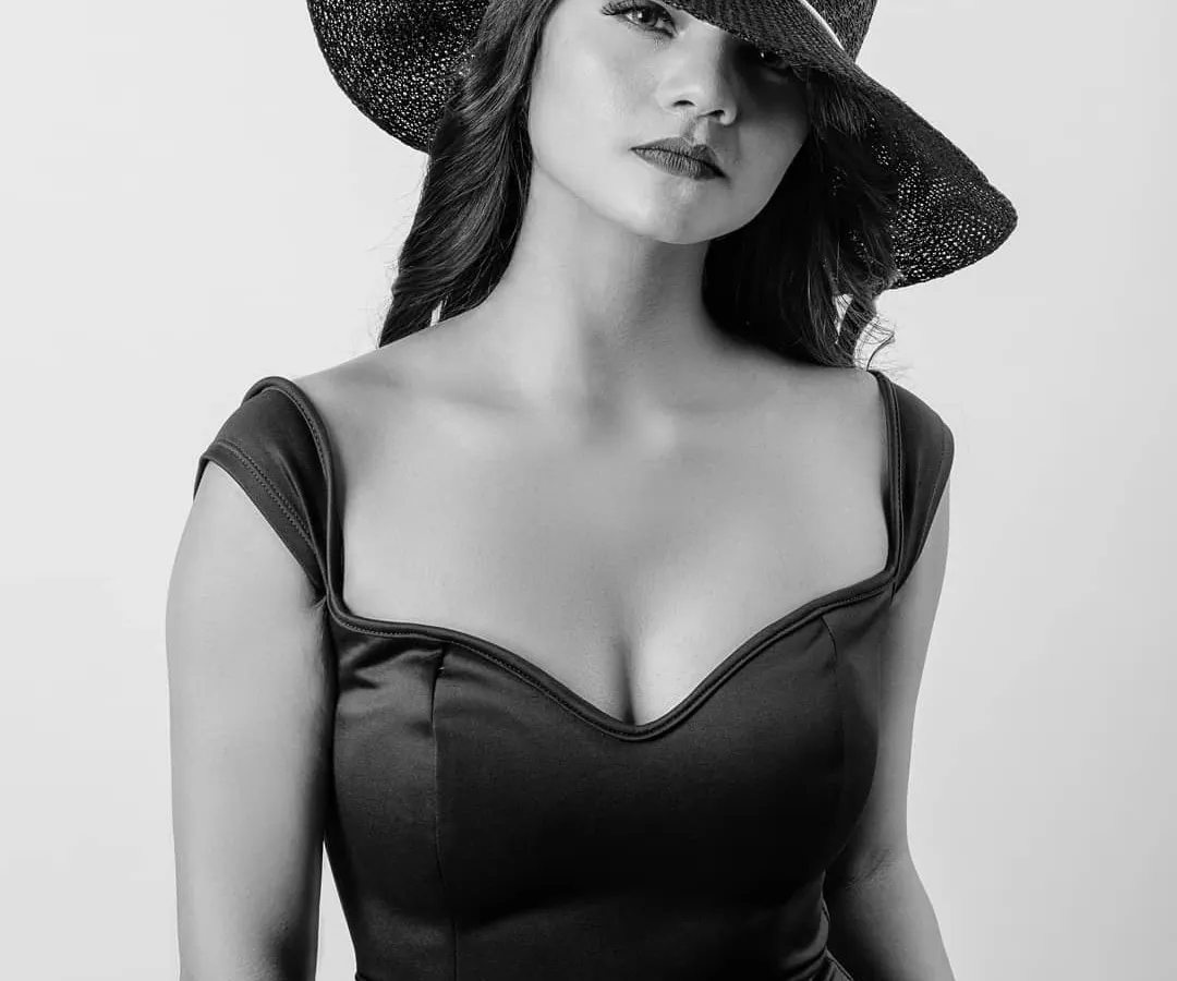 A timeless black and white portrait that plays with shadow and mystery. The wide-brimmed hat conceals just enough to draw you in, showcasing a classic, elegant look perfect for a high-fashion portfolio.