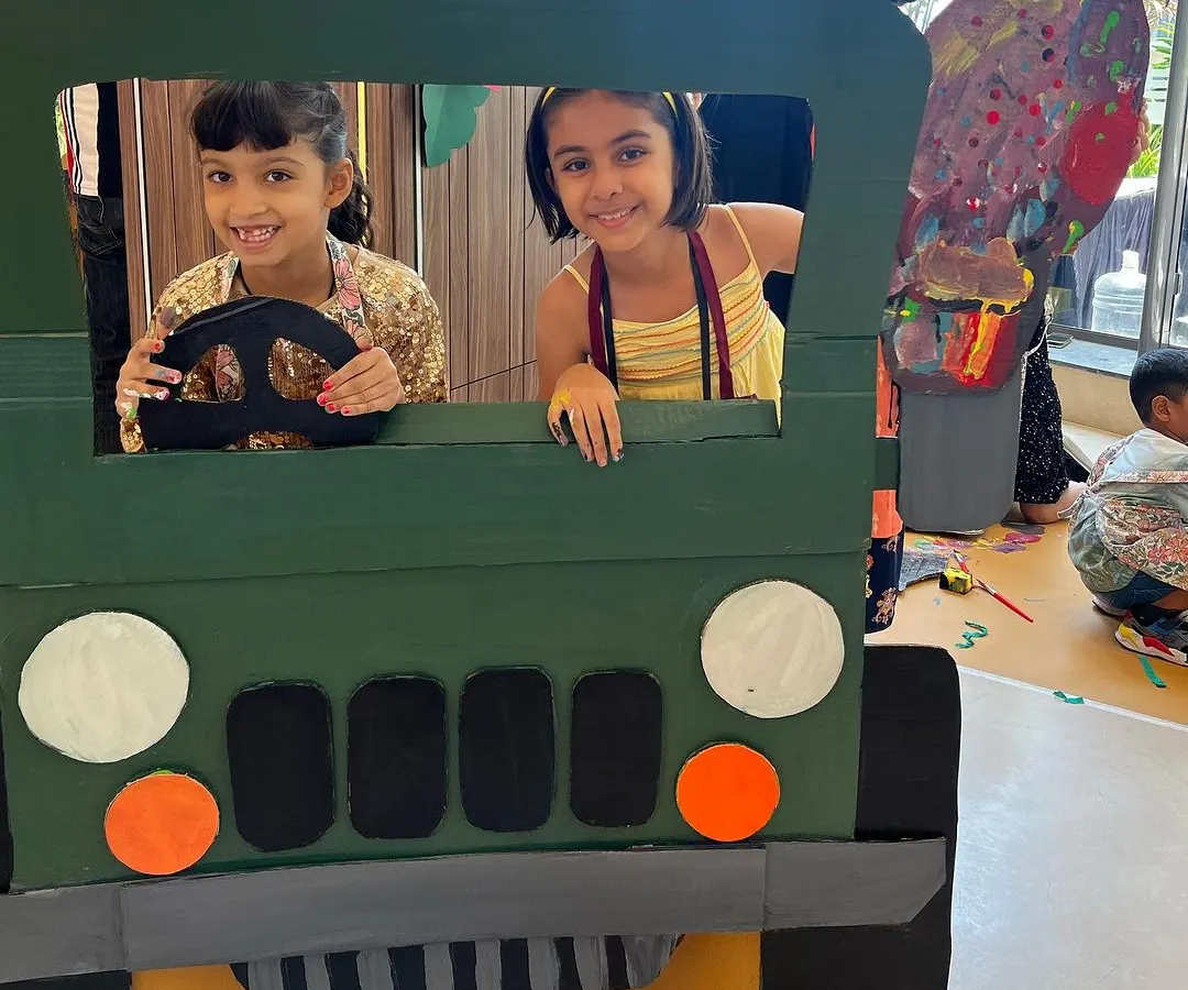 Our workshops are not just about painting; they are about building worlds. Here, two of our campers are ready to drive off on a jungle safari in a jeep they helped design and paint themselves. This is where 3D construction meets imaginative play.