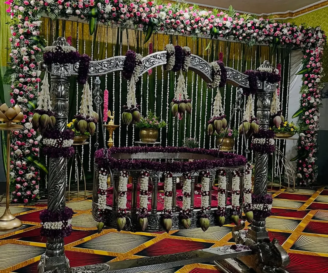 For a naming ceremony, the thottil (cradle) is the heart of the event. I adorn it with intricate floral arrangements, like these jasmine and lotus bud garlands on an ornate silver cradle, making it a beautiful centerpiece for welcoming your little one.