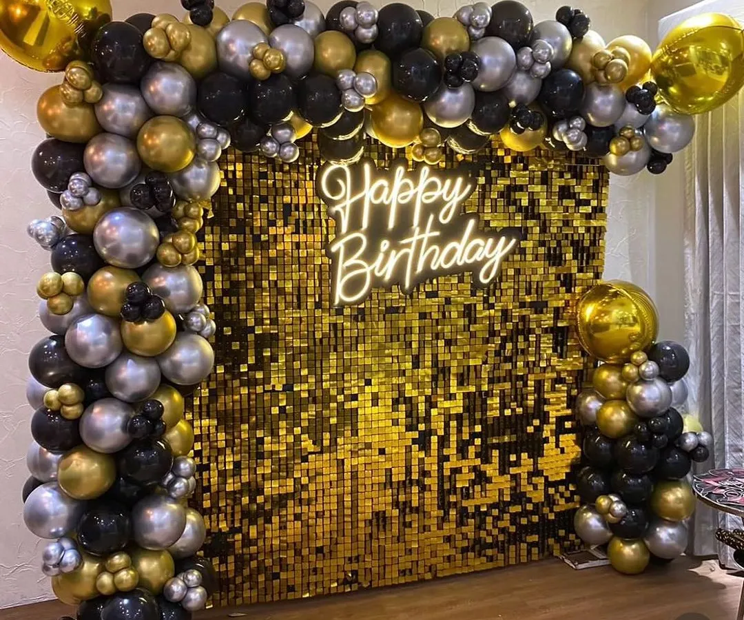For a stylish and modern celebration, I designed this stunning photo booth with a gold shimmer wall. The setup is framed by a black, gold, and silver balloon arch and lit by a "Happy Birthday" neon sign, perfect for milestone birthdays and elegant parties.