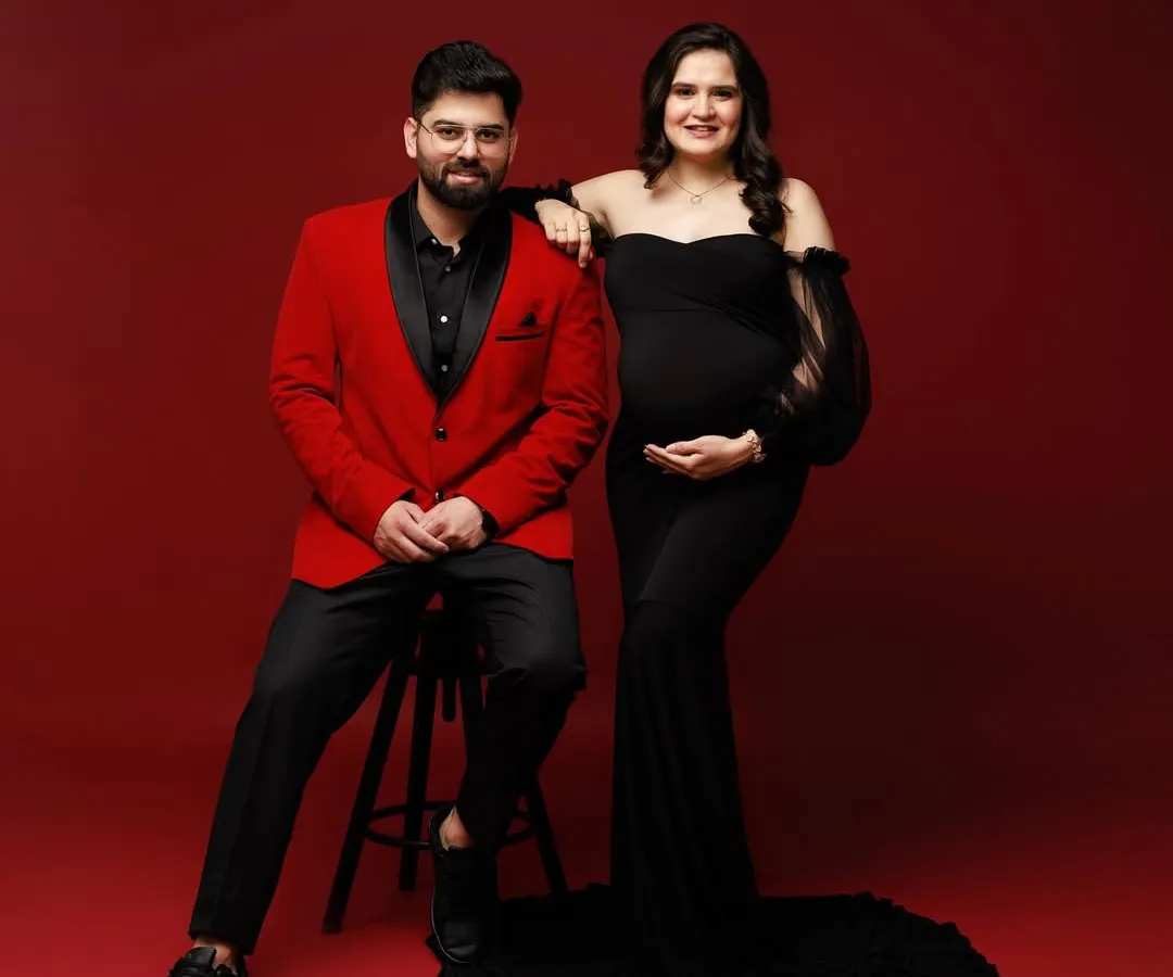 A portrait of partnership and anticipation. I love capturing the strength and connection between couples as they await their new arrival, using bold colors like red and black to reflect their passion.
