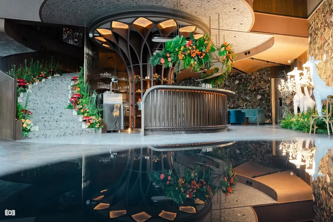 Welcome to the 'Citrus Safari'. We transformed this reception venue into a vibrant jungle with a custom-designed bar, tropical florals, and a stunning water reflection that doubled the magic.