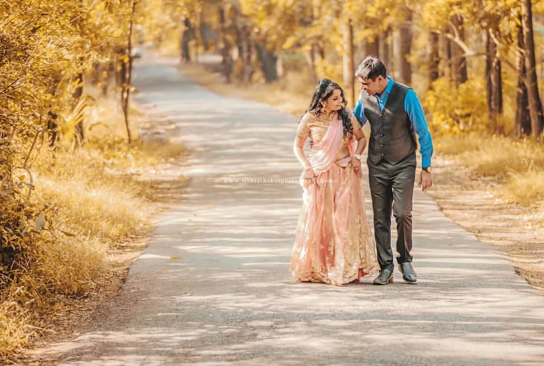 A pre-wedding shoot is like taking a walk into your future together. This cinematic shot on a quiet, tree-lined road captures the start of that beautiful journey.