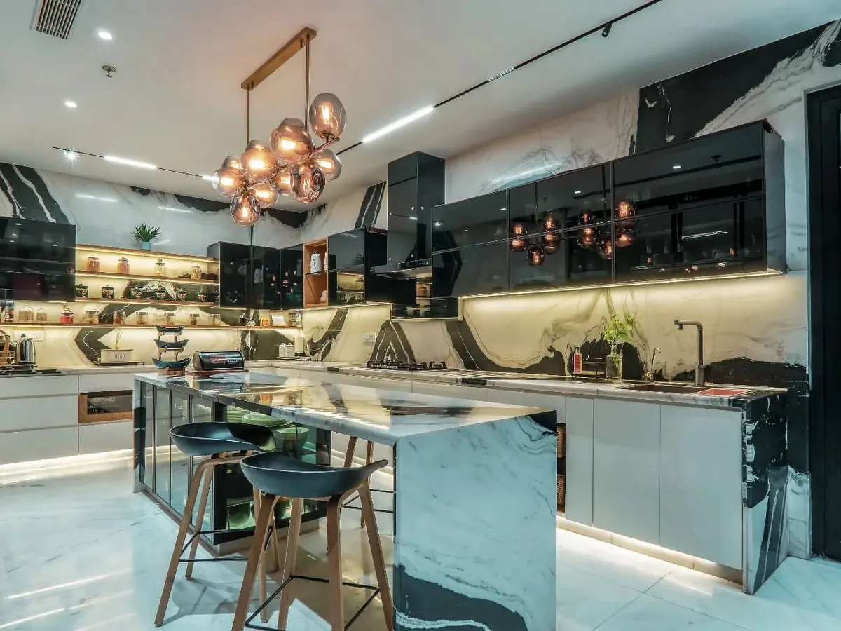 This kitchen is conceived as the heart of the home, blending function with high-end aesthetics. We used bookmatched Panda marble for the island and backsplash, complemented by sleek, high-gloss cabinetry and layered lighting, including a statement pendant fixture.