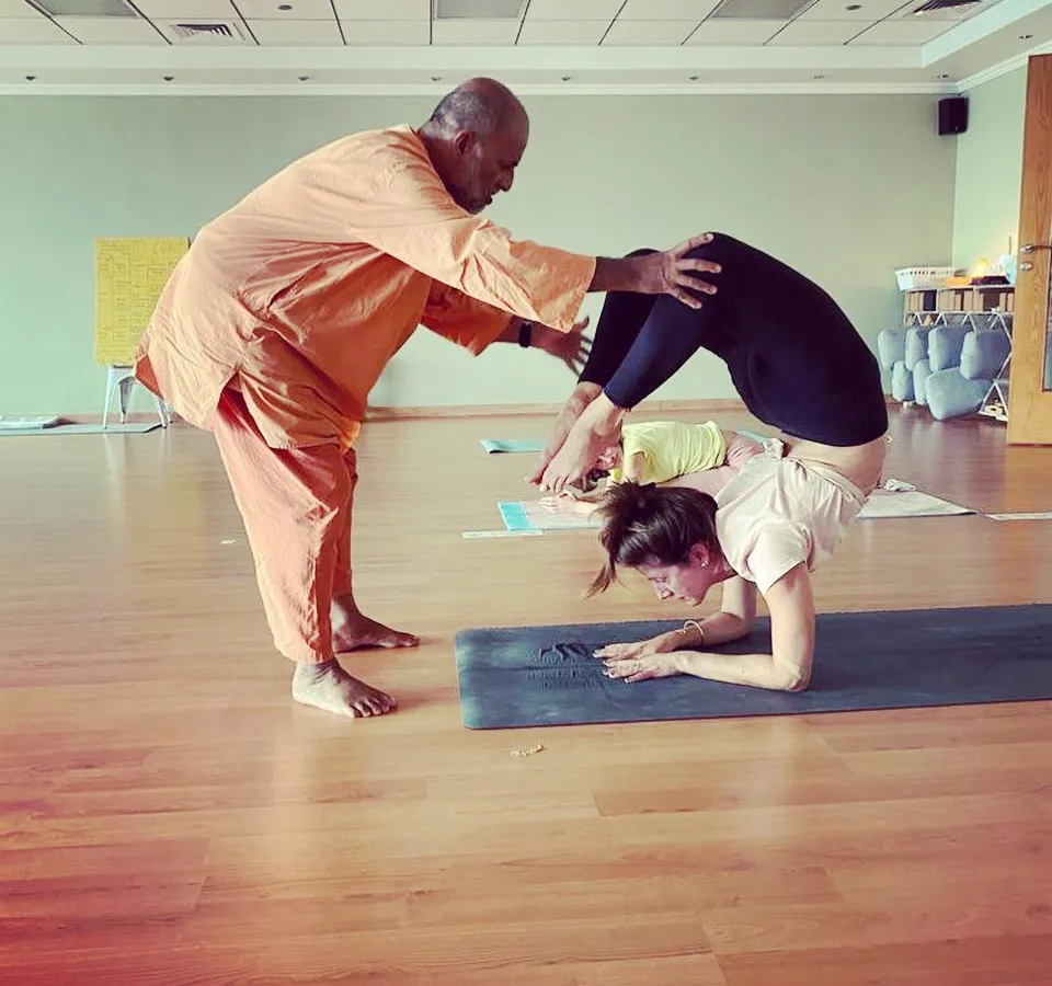 Personal guidance is the cornerstone of my teaching. Here, I assist a student in deepening their Vrischikasana (Scorpion Pose), ensuring safe alignment while helping them explore their physical and mental potential.