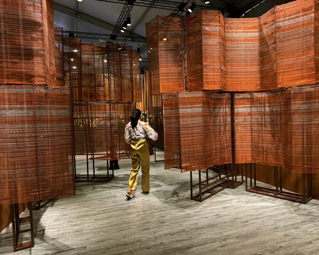 This walkthrough installation explores the dialogue between tradition and industry. We meticulously hand-wove copper wires on a loom in our studio, creating a flowing, multi-dimensional sculpture. The metallic surface acts like a gleaming river, reflecting India's rich history while embracing a contemporary aesthetic.