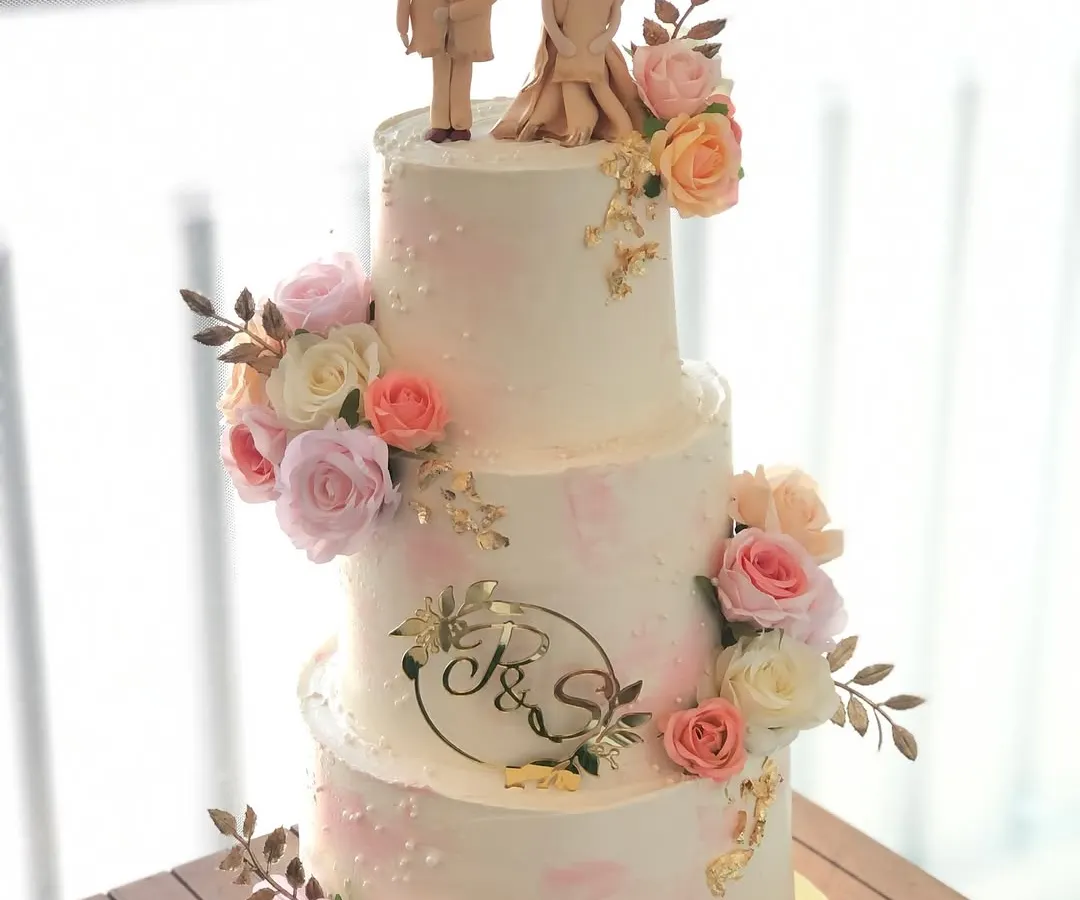 A three-tiered engagement cake for a beautiful new beginning. I designed this piece with delicate blush tones, fresh flowers, and custom fondant toppers of the couple.