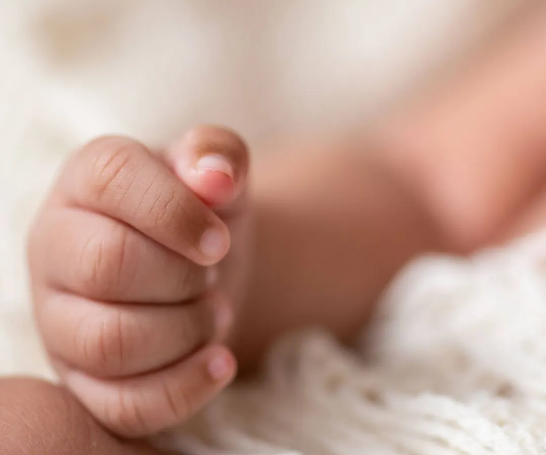 It's the little things that you'll want to remember forever. This close-up shot focuses on the delicate, tiny fingers of a newborn, capturing the fleeting details that make this time so precious. We believe these macro detail shots are an essential part of any newborn gallery.