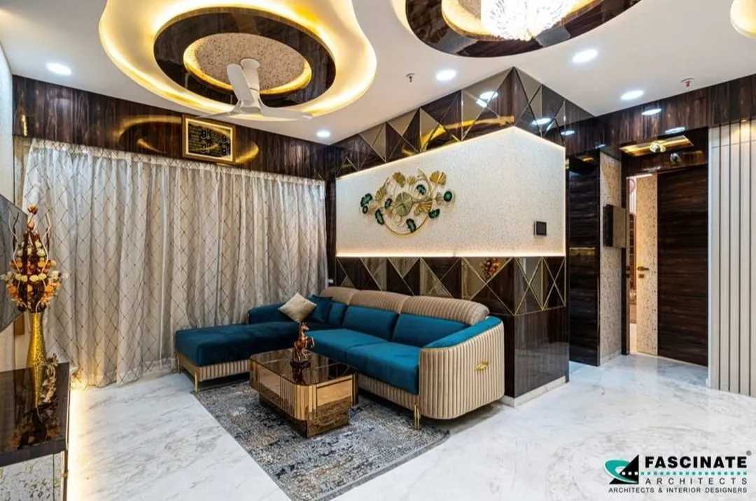This living room in Jogeshwari is the epitome of modern luxury. We designed a complex, multi-layered ceiling with cove lighting to create drama and warmth. The combination of a plush teal sofa, reflective geometric wall panels, and bespoke furniture creates a space that is both glamorous and inviting, perfect for entertaining or relaxing.