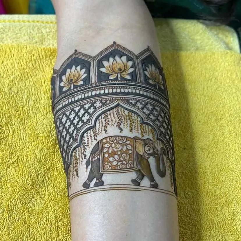 I love creating unique armband designs. This piece features a majestic elephant under a traditional archway, surrounded by lotus flowers, all done with my organic henna.