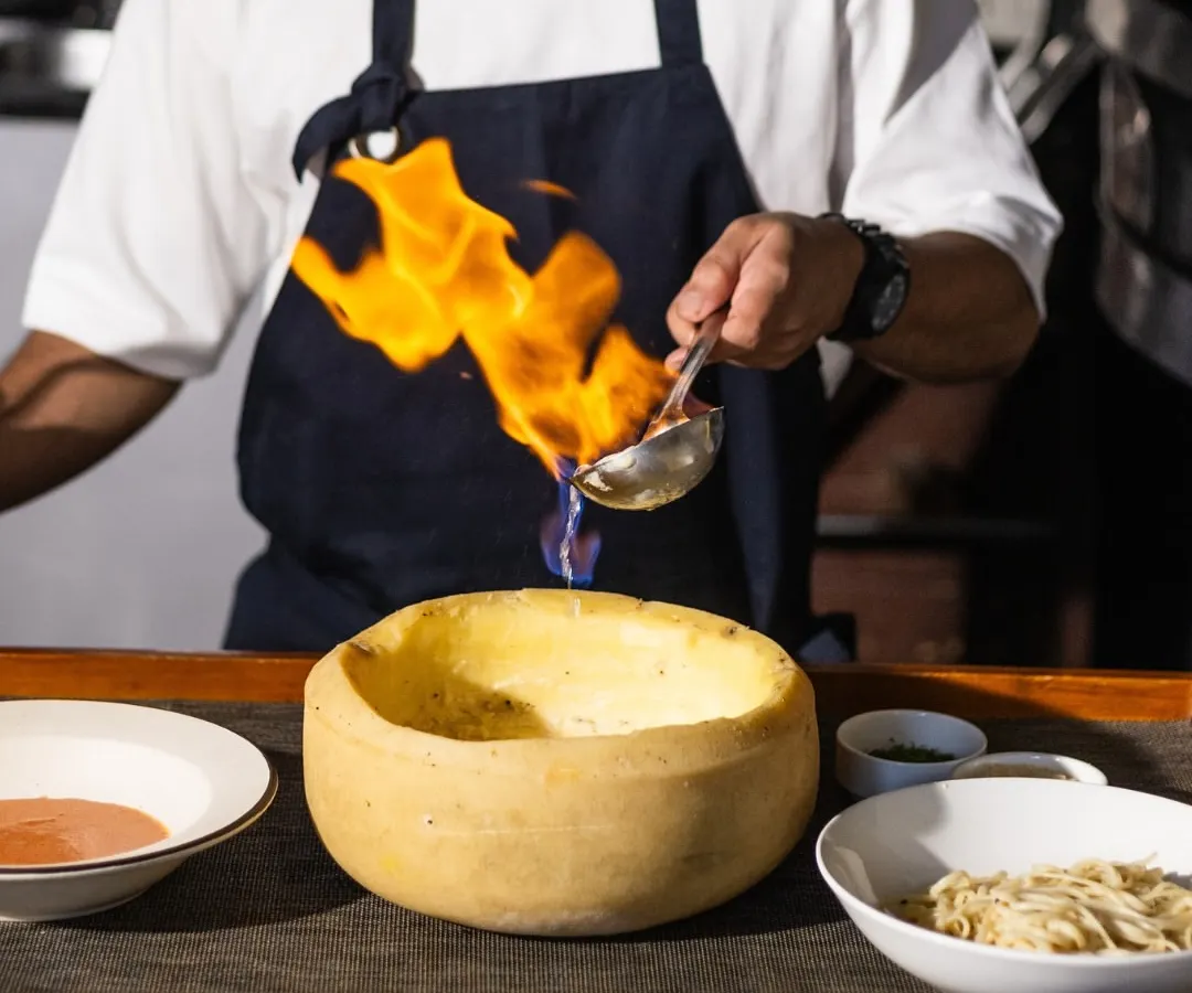 Get ready for a little drama at your table. I love finishing our famous Vodka Pasta in a wheel of Parmesan, flambéed right in front of you. It’s not just a dish, it’s an experience that brings the heat and flavor together.