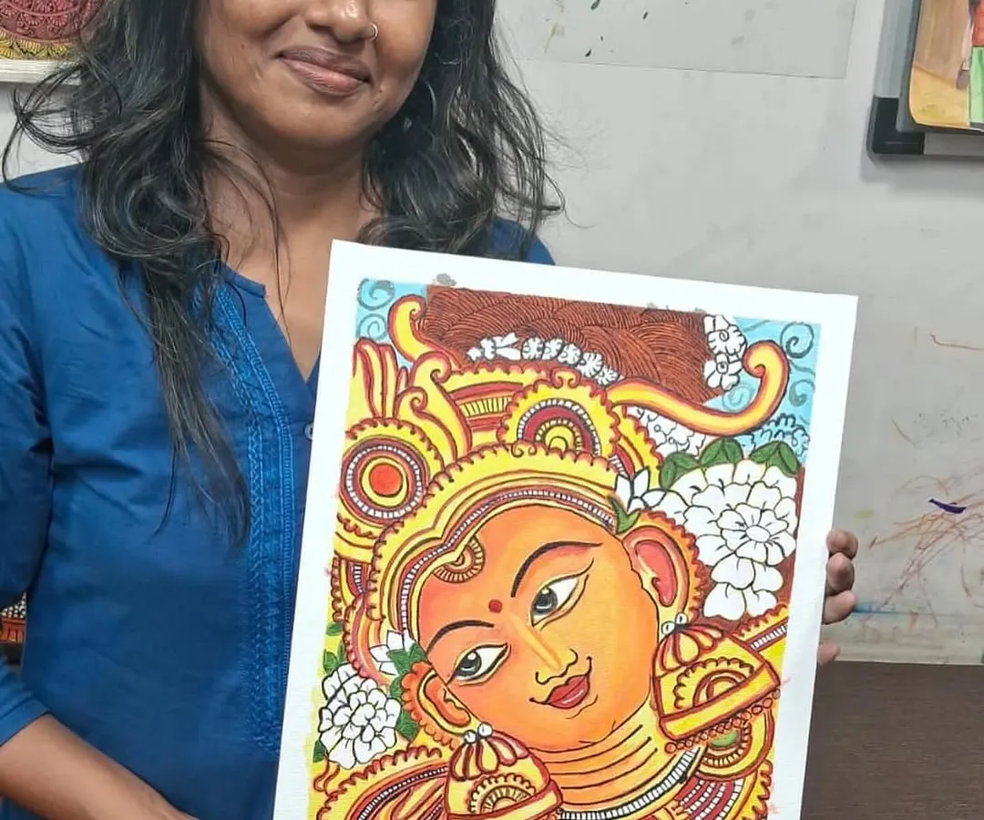 Here is one of our dedicated students proudly displaying her finished Kerala mural. It's so rewarding to watch our adult students master this traditional art form with such focus and passion.