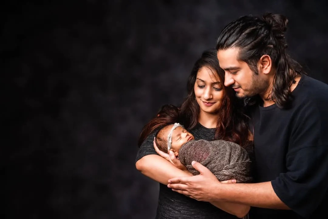 A beautiful moment between new parents as they lovingly gaze at their newborn baby. These parent and baby portraits are about capturing that pure, early connection.