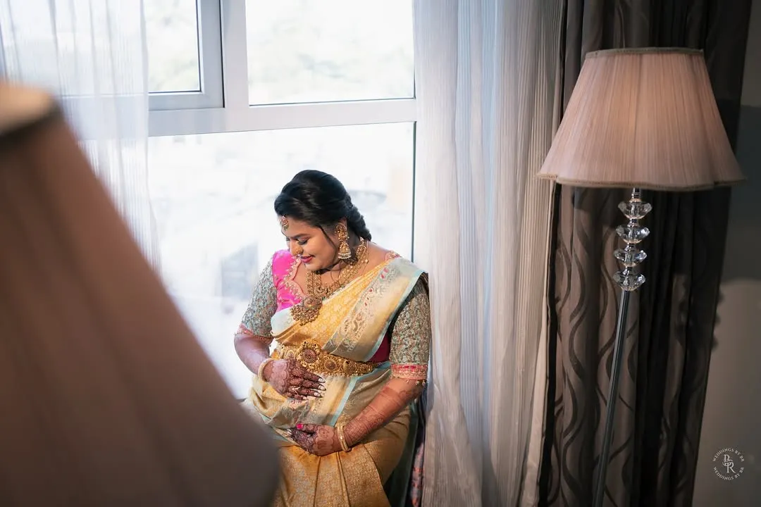 The quiet beauty of a mother-to-be, bathed in soft window light. This portrait captures the serene pregnancy glow and anticipation during her Seemantha.