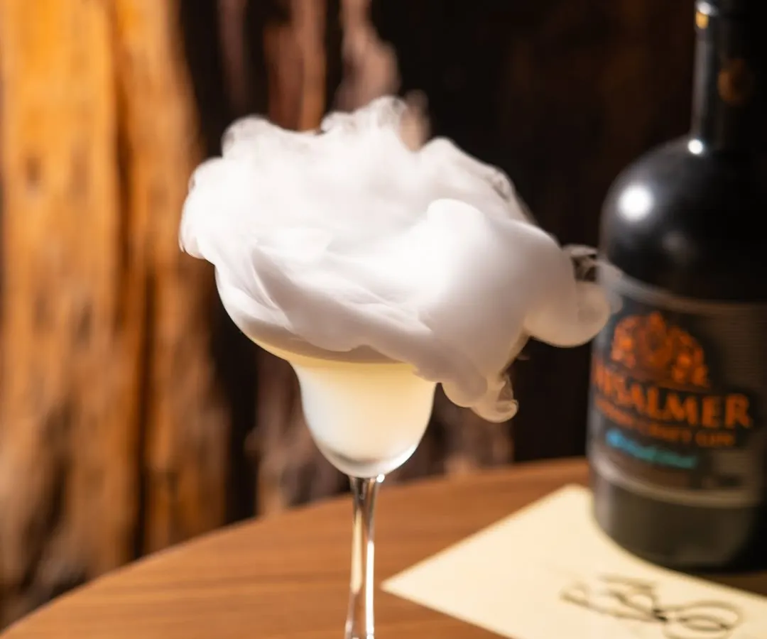 Creating drama with a smoky gin cocktail. This kind of shot is perfect for a bar's social media, creating intrigue and highlighting the craft behind the drink.