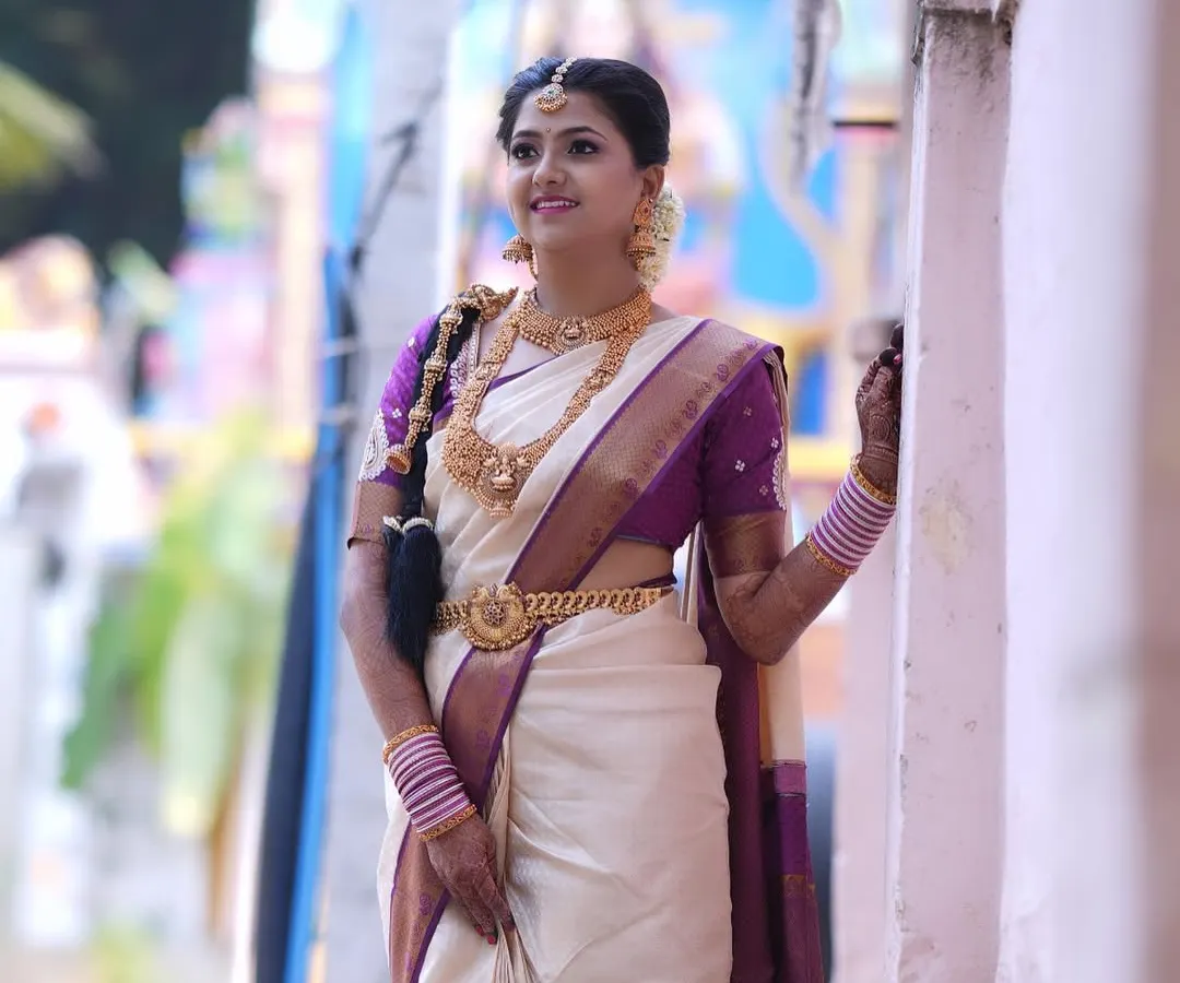 For my beautiful South Indian brides, it's all about timeless elegance. This Murtham look features glowing skin, defined eyes, and makeup that enhances her features while perfectly matching the grandeur of her silk saree and temple jewellery.