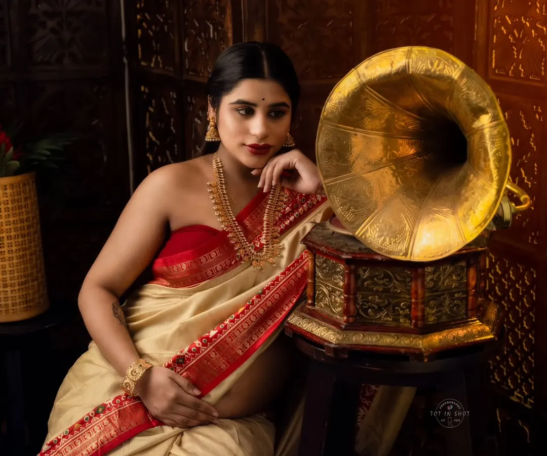 We blend tradition with art in this conceptual maternity saree shoot. This portrait, inspired by classic Indian aesthetics with a vintage gramophone, captures a timeless elegance and quiet contemplation.