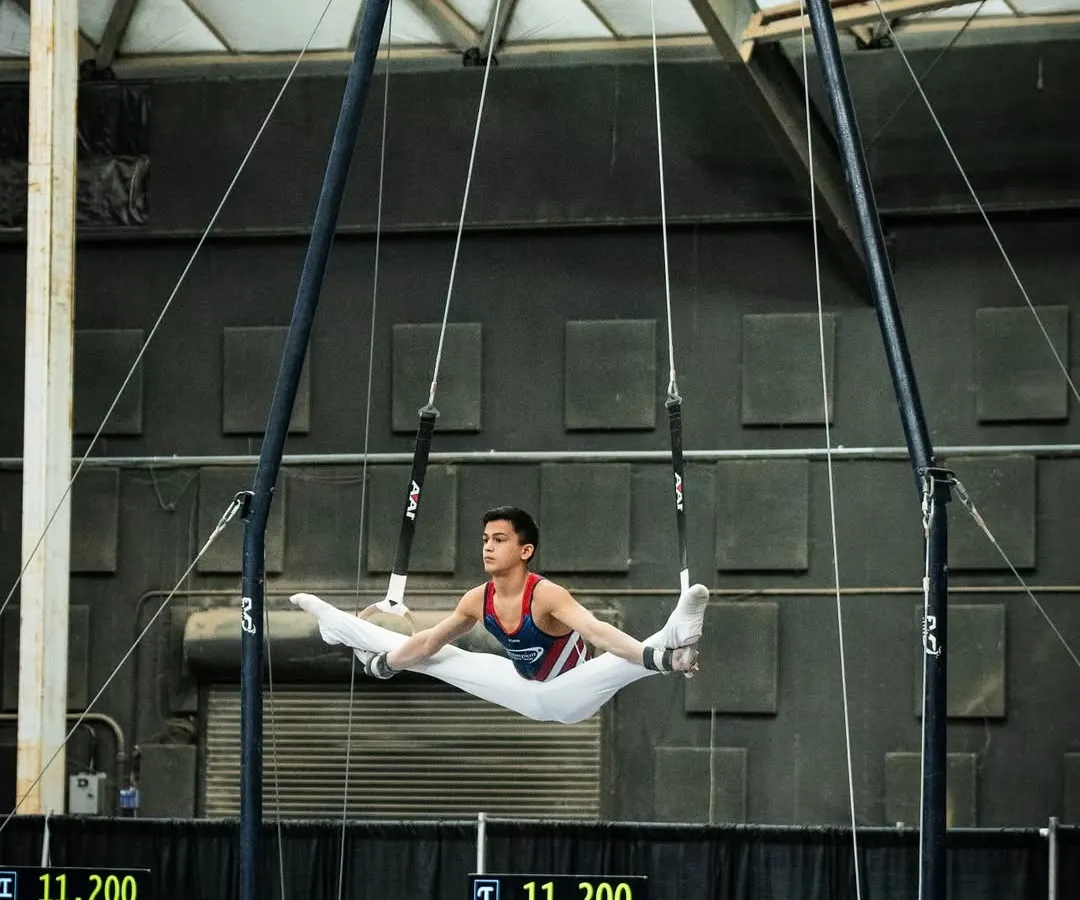 This is what dedication looks like! Here's one of our advanced athletes, Zachary, demonstrating incredible strength and form on the still rings during a national competition. We train gymnasts to reach their highest potential.