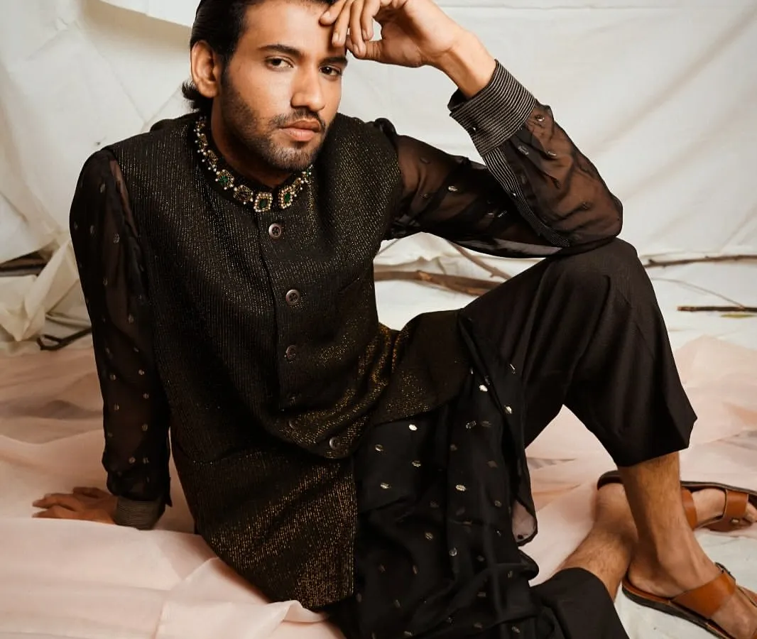 For this menswear look, I focused on creating a contemplative and sophisticated mood. The soft studio lighting highlights the texture of the sheer black kurta and the detailed embroidery on the bandhgala jacket, presenting a modern take on traditional Indian attire.