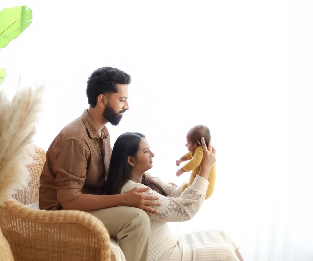 Welcoming a new baby is a family affair. We always include portraits with parents in our sessions, capturing the love and connection in a natural, light-filled studio setting.