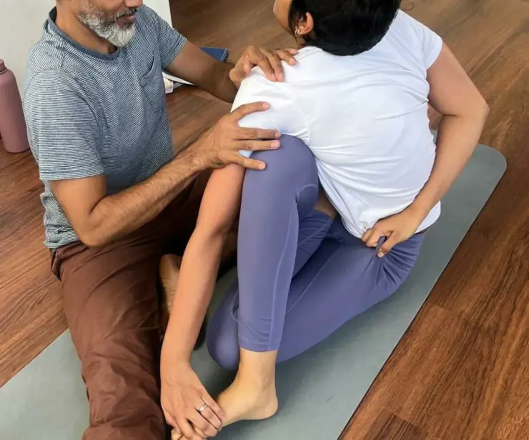 My teaching philosophy is centered on providing direct, hands-on guidance to ensure you practice safely and effectively. In this photo, I am assisting a student to deepen her seated twist, helping her find the correct alignment in Purna Ardha Matsyendrasana to maximize the posture's benefits.