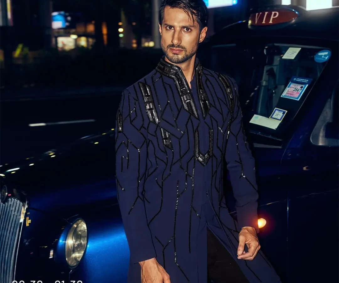 I designed this piece for the man who owns the night. The deep blue fabric is structured with architectural, hand-embroidered patterns, creating a look of unapologetic power. It is a modern statement for a cocktail event or a grand reception.