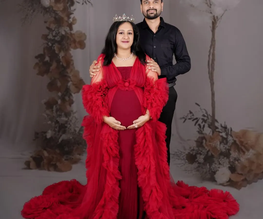 We believe every mother is a queen, and this portrait session is designed to celebrate that. Dressed in a magnificent red gown against a floral backdrop, this mom-to-be radiates strength and beauty, creating a regal and unforgettable maternity portrait.