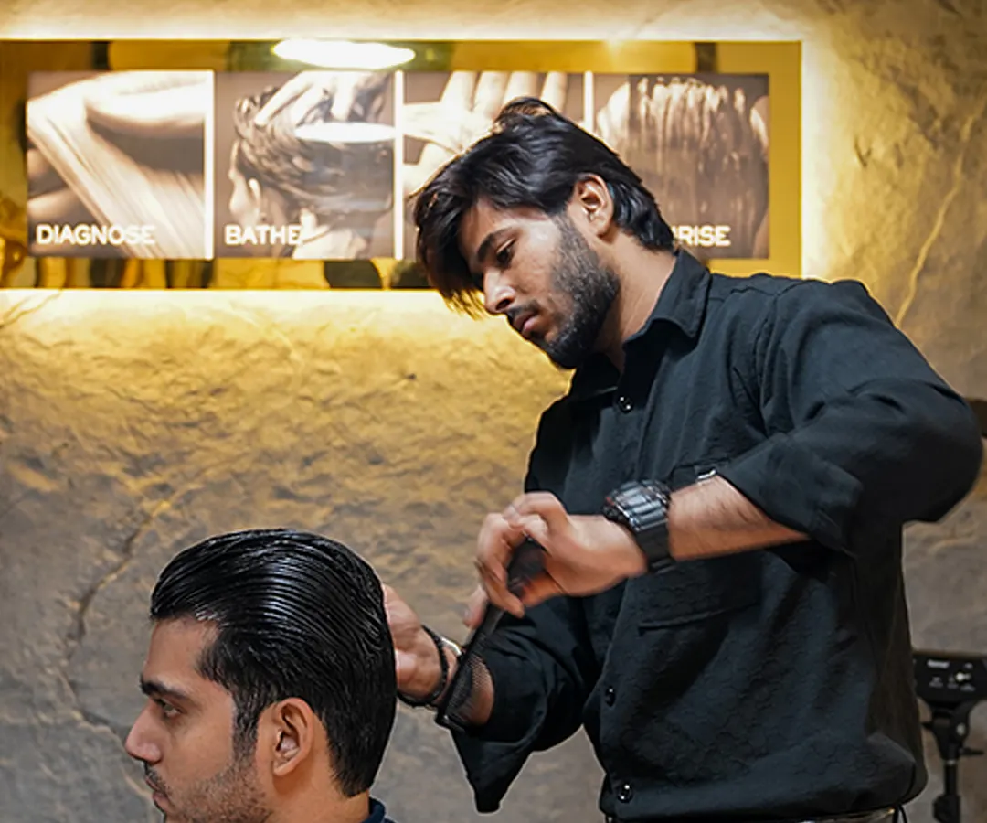 It's all in the details. Here, one of our expert stylists focuses on creating clean lines and perfect texture for a classic men's haircut, using premium Kérastase products for a flawless finish.